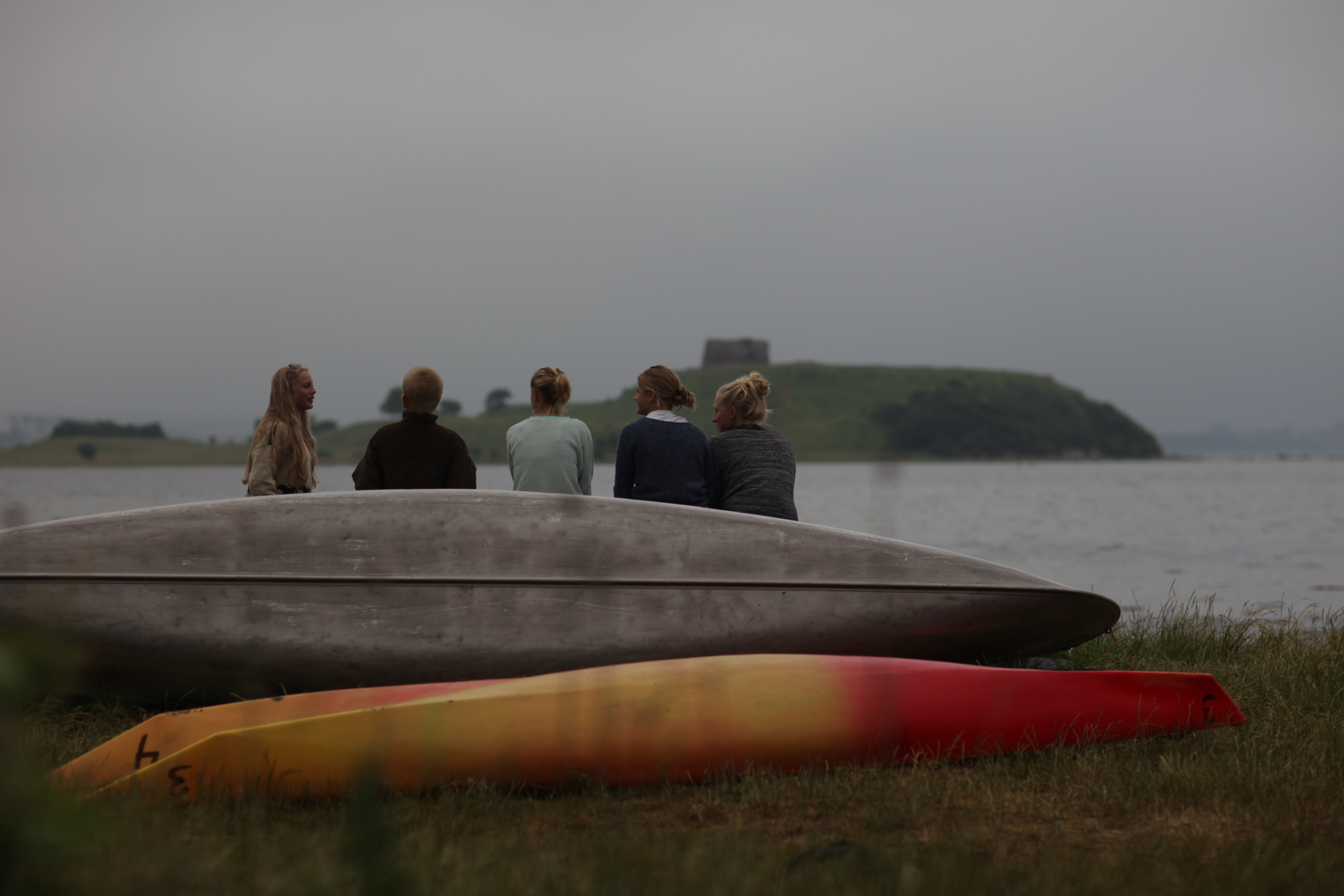 Mennesker sidder på kajak og betragter udsigten med Kalø Slotsruin i horisonten